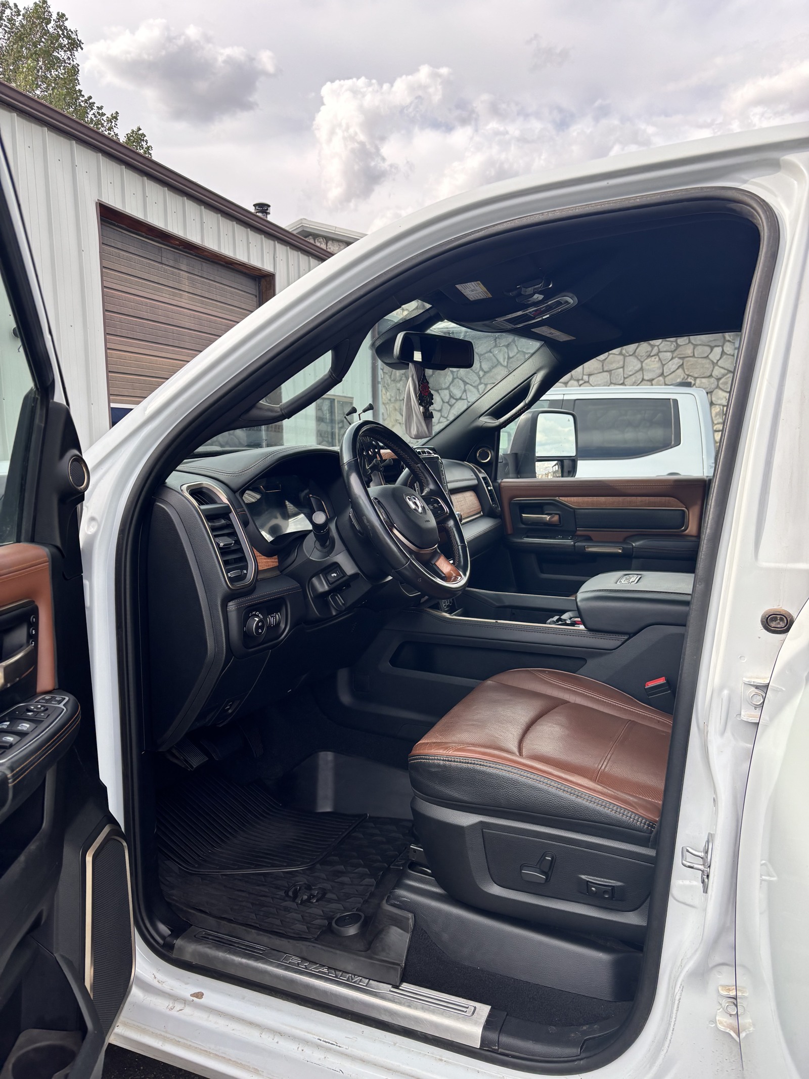 After detailing: the same Ram truck with a cleaned driver’s floor mat, dashboard and brown leather seat
